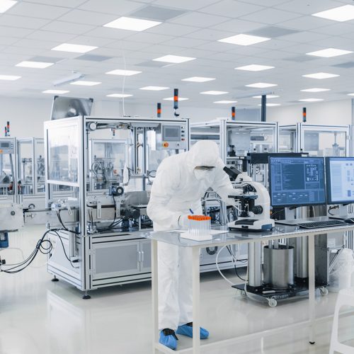 Shot of Sterile Pharmaceutical Manufacturing Laboratory where Scientists in Protective Coverall's Do Research, Quality Control and Work on the Discovery of new Medicine.
